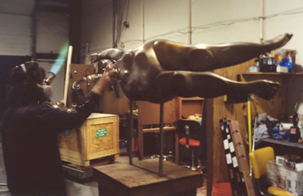 "Meg", of Bedford & Coulter Studios heats the sculpture as the patina is applied.